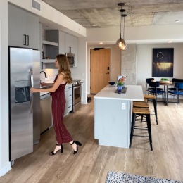 Spacious kitchens with thoughtful details a person in a kitchen with a refrigerator and an island with seating