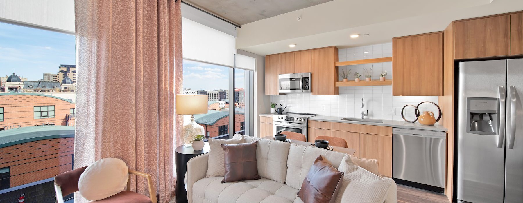 a living room with large windows a couch and a table