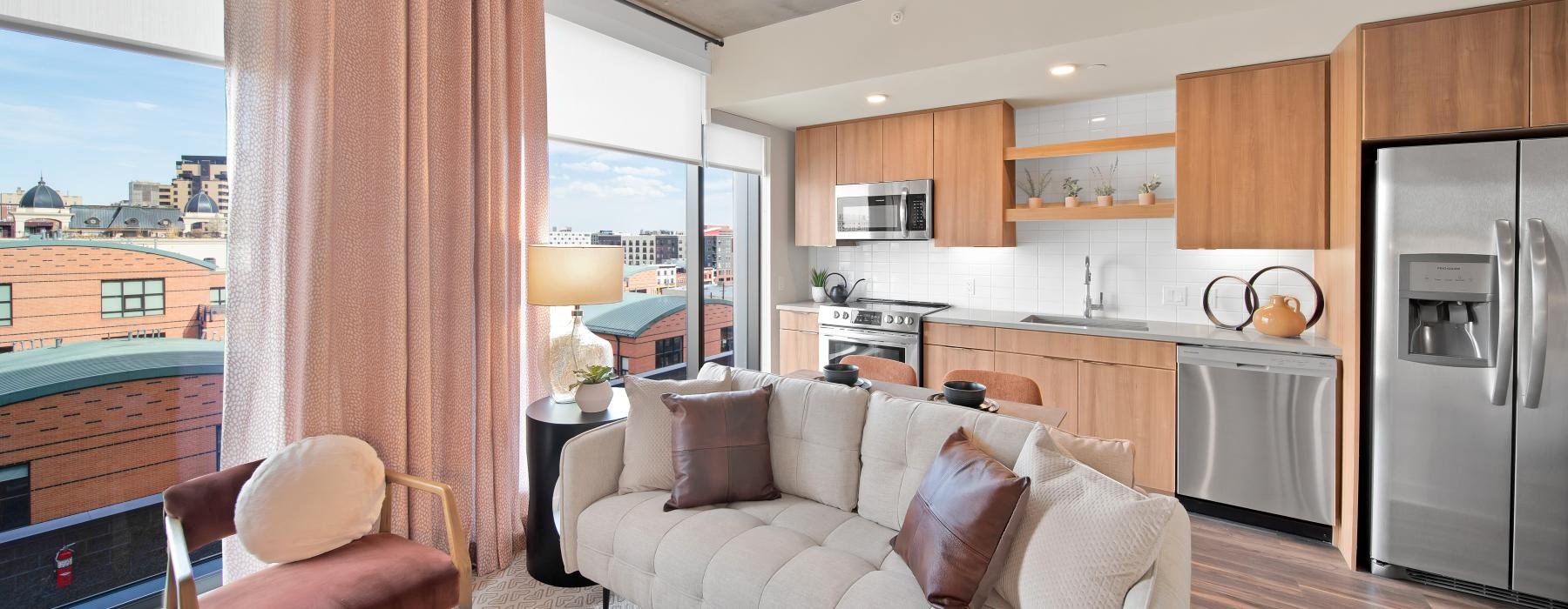a living room with large windows a couch and a table