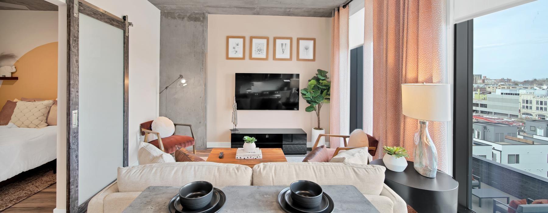 a living room with a tv table and large window
